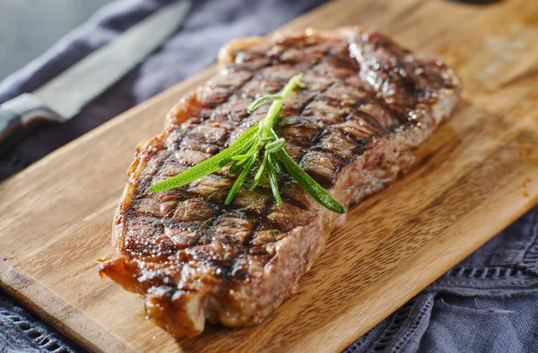 Grillezett New York Szalag Steak Pihenő Vágódeszkán Rozmaringos Díszítéssel — Stock Fotó