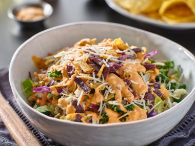Kıtır kıtır Meksika salatası, çok renkli tortilla şeritleri ve chipotle soslu.