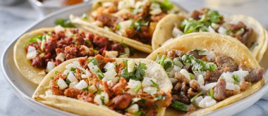 Meksika sokak tacoları, karne asada, sucuk ve mısır tortillasında al pastor.