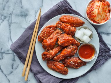 Baharatlı gochujang soslu Kore usulü kızarmış tavuk ve turp turşusu.