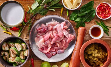 Thai yeşili körili tavuk tarifi ve ahşap masa üstünde hazırlanmış tüm malzemeler.