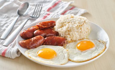 Filipino Silog kahvaltısı, sarımsaklı pilav, longsilog, ve iki güneşli yumurta.