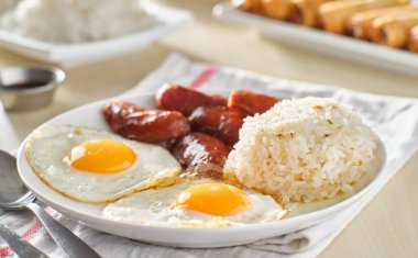 Filipino Silog kahvaltısı, sarımsaklı pilav, longsilog, ve iki güneşli yumurta.