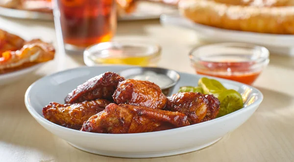 plate of fried bbq chicken wings with ranch and celery