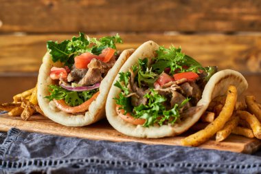 iki Yunan jiroskopu patates kızartması, domates ve marul