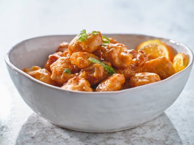 Bir kase portakallı tavuk masanın üstünde.