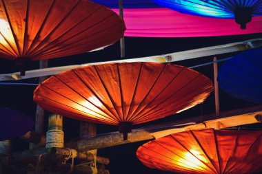 Tavandan sarkan kırmızı ve yeşil renkli şemsiye desenli klasik elektrik lambaları.