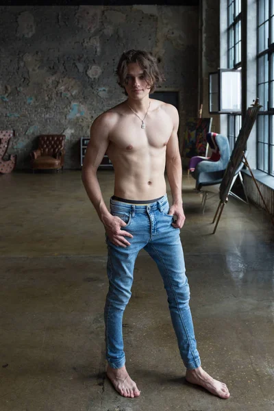 Handsome blond male model with blue eyes full body posing indoors