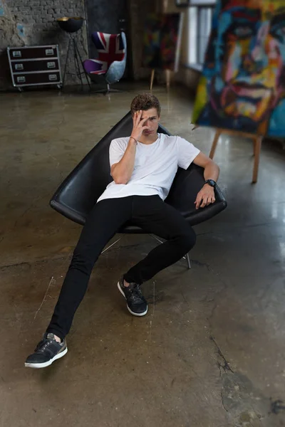 Cute Young Guy Brown Hair Sitting Black Chair Closing One — Stock Photo, Image