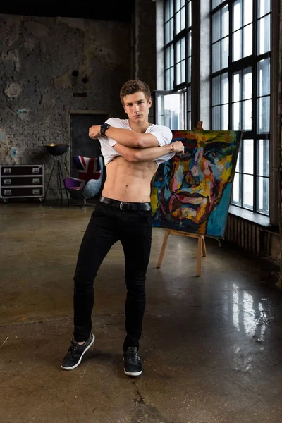 Yakışıklı genç erkek model kahverengi saçlı, beyaz gömlek, modern iç profesyonel photostudio alarak altı paketi gösterilen