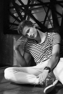 Çizgili gömlek ve beyaz pantolon modern iç photostudio poz yakışıklı genç erkek modeli