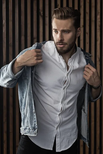 Kahverengi saçlı ve mavi kot sakallı yakışıklı modeli.