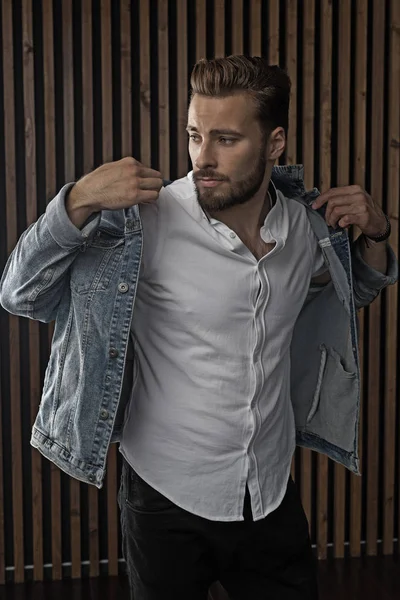 Kahverengi saçlı ve mavi kot sakallı yakışıklı modeli.