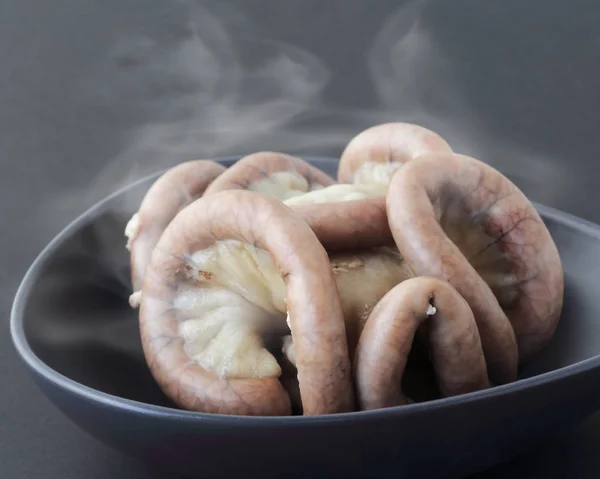 Boiled chitterlings internal organs of pig on gray with smoke.