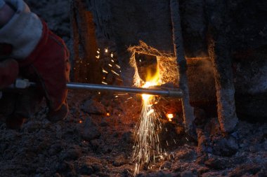Eriyen metal damlaları ve kıvılcımları olan kaynak makinesi..