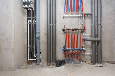 Bir beton duvar arka planda Isıtma ve su sisteminin boruları.