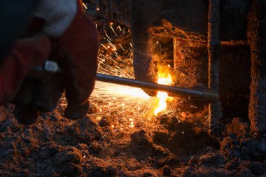 Eriyen metal damlaları ve kıvılcımları olan kaynak makinesi..