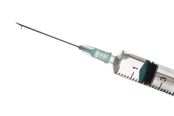 The end of the syringe with a needle filled with liquid on a lig — Stock Photo, Image