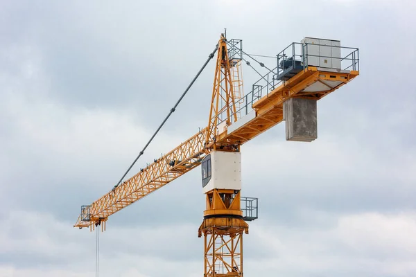 Fragment of a tower crane with a cabin on a background of blue s — Stock Photo, Image