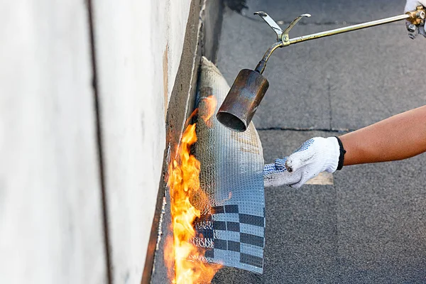 La colocación de impermeabilización por calefacción techado fieltro con fuego. —  Fotos de Stock