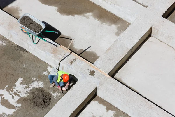 제복을 입은 일꾼들이 건축 현장에서 모래를 청소하는 모습, 맨 위에서 본 광경. — 스톡 사진