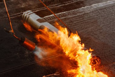 Çatı döşeme rulo hissetti Yakın çekim bir alev ile.