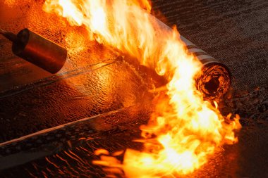 Çatı döşeme rulo hissetti Yakın çekim bir alev ile.