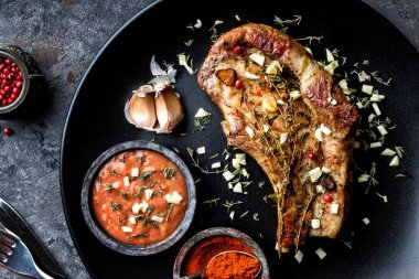 sarımsak ve kekik koyu arka plan üzerinde koyu plaka kızarmış domuz eti biftek