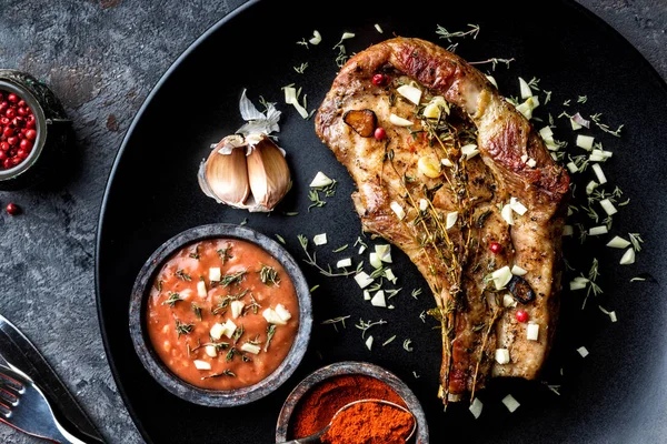 sarımsak ve kekik koyu arka plan üzerinde koyu plaka kızarmış domuz eti biftek