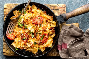 Makarna farfalle kavrulmuş et ve bir tavada domates ile