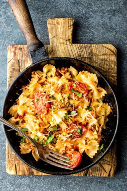 Makarna farfalle kavrulmuş et ve bir tavada domates ile