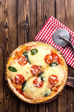 pizza margarita üstten görünüm rustik ahşap bir masa üzerinde Margherita İtalyan mutfağının geleneksel tarifi göre pişirilir.