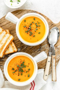 üstten görünüm, hafif bir arka plan beyaz kase kabak veya havuç veya tatlı patates sebze çorbası servis