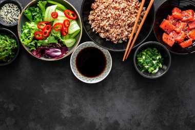 poke kase maddeler - kahverengi pirinç, alabalık ya da somon fileto, Chuka yosun salata, susam ve taze sebze, üstten görünüm, mutfak arka plan kopya alanı, sağlıklı gıda arka plan