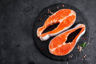 Siyah arka planda çiğ somon balığı biftekleri