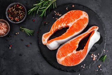 Siyah arka planda çiğ somon balığı biftekleri