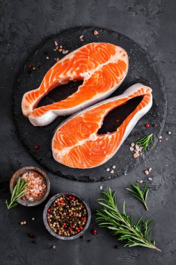 Siyah arka planda çiğ somon balığı biftekleri