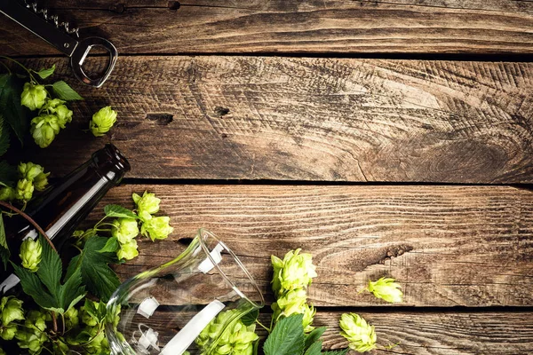古い木製のテーブルの上に空のビールグラス ボトル 新鮮なホップのビールの背景 トップビュー テキストのスペース — ストック写真