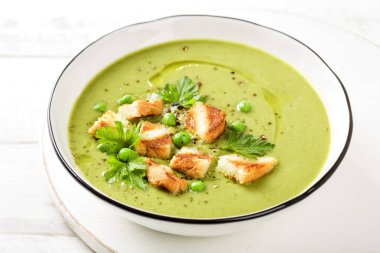Bezelye çorbası. Izgara tost ile servis edilen bir kapta yeşil bezelye püresi çorbası, üst görünümü