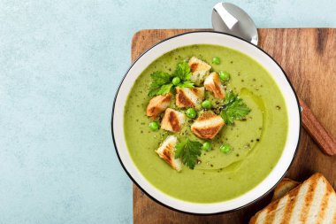 Bezelye çorbası. Izgara tost ile servis edilen bir kapta yeşil bezelye püresi çorbası, üst görünümü