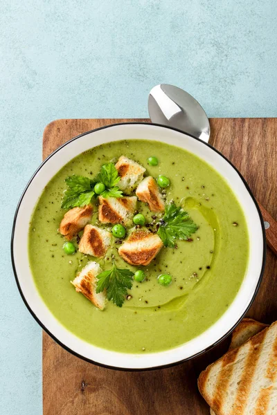 Bezelye çorbası. Izgara tost ile servis edilen bir kapta yeşil bezelye püresi çorbası, üst görünümü