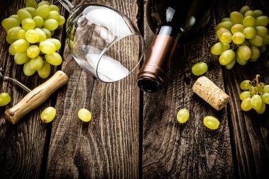 açık şarap şişesi, şarap bardağı ve bir metin için boş alan ile koyu ahşap rustik arka plan üzerinde beyaz üzüm dalları şarap arka plan