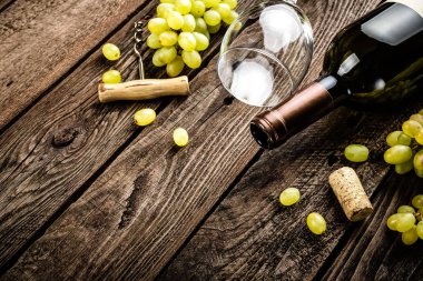 açık şarap şişesi, şarap bardağı ve bir metin için boş alan ile koyu ahşap rustik arka plan üzerinde beyaz üzüm dalları şarap arka plan