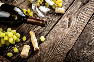açık şarap şişesi, şarap bardağı ve bir metin için boş alan ile koyu ahşap rustik arka plan üzerinde beyaz üzüm dalları şarap arka plan