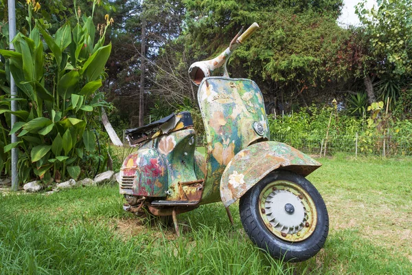 Una vieja motocicleta pintada abandonada en un jardín en la isla de Corfú — Foto de Stock
