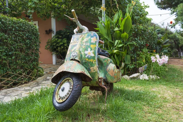 Una vieja motocicleta pintada abandonada en un jardín en la isla de Corfú — Foto de Stock
