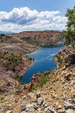 Yunanistan 'ın Evia kentindeki kayalık yamaçlar ve seyrek yeşilliklerle çevrili Triadas Gölü' ndeki turkuaz suların canlı bir görüntüsü.