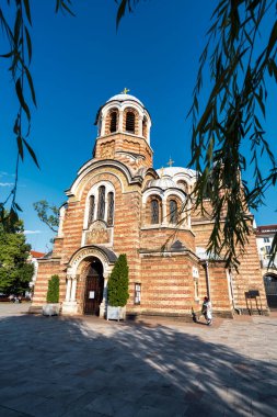 Sofya, Bulgaristan - 5 Ağustos 2025: Bulgaristan 'ın Sofya kentindeki Saint Sedmochislenitsi Kilisesi' nin dış görünümünde kubbeler ve tuğla cepheli Neo-Bizans mimarisi yer alıyor.