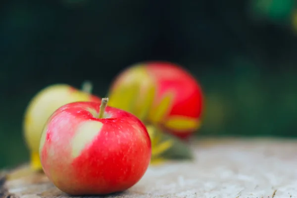 在木板上的新鲜苹果特写 苹果和秋黄叶在背景苹果采摘的概念 秋季收获 侧面景观 — 图库照片