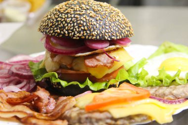 Siyah burger kırmızı soğan, kaşar peyniri ve patates kızartması. Portre. Fast food Restoran, yemek festivali kavramı